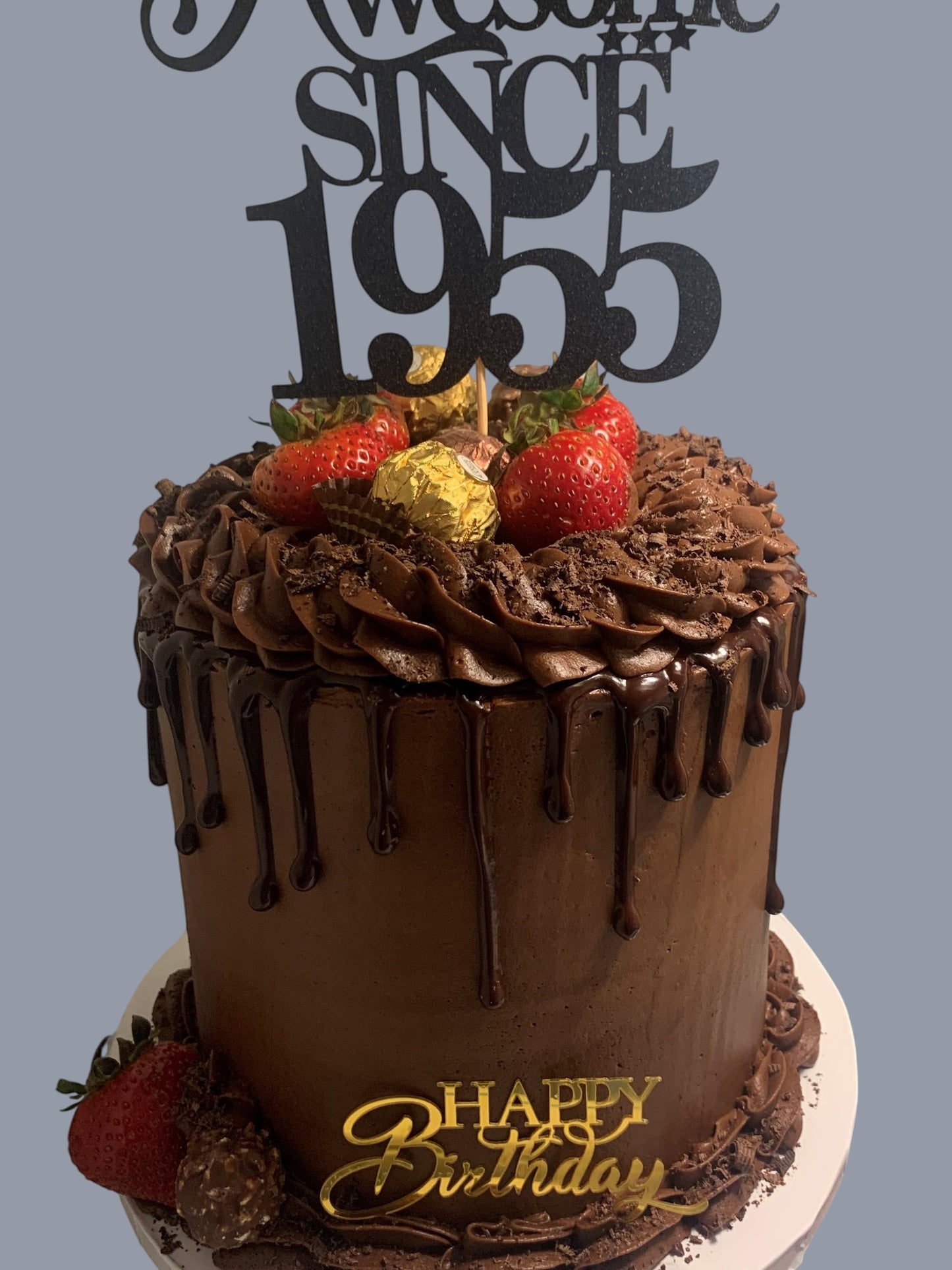 Sarah's Cakes chocolate drip cake with strawberries, Ferrero Rocher, and "Awesome Since 1955" topper.