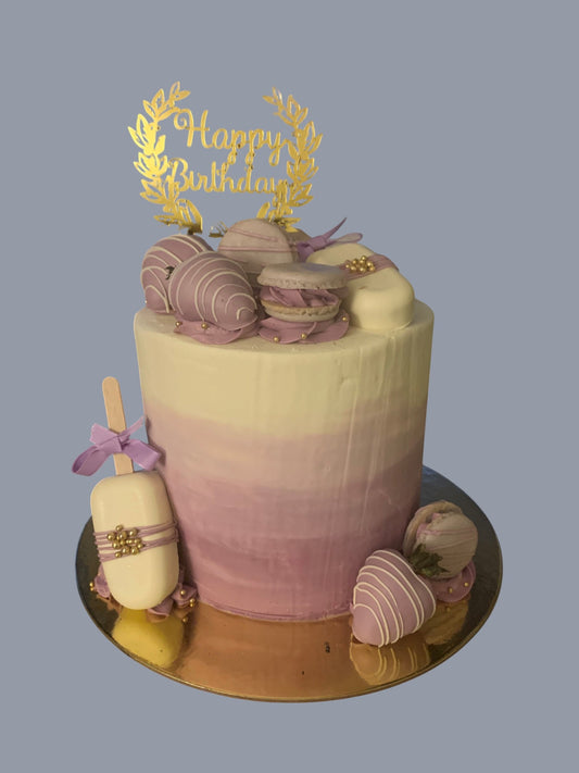Sarah's Cakes ombre purple and white cake with macarons, chocolate-covered strawberries, and a cake pop.