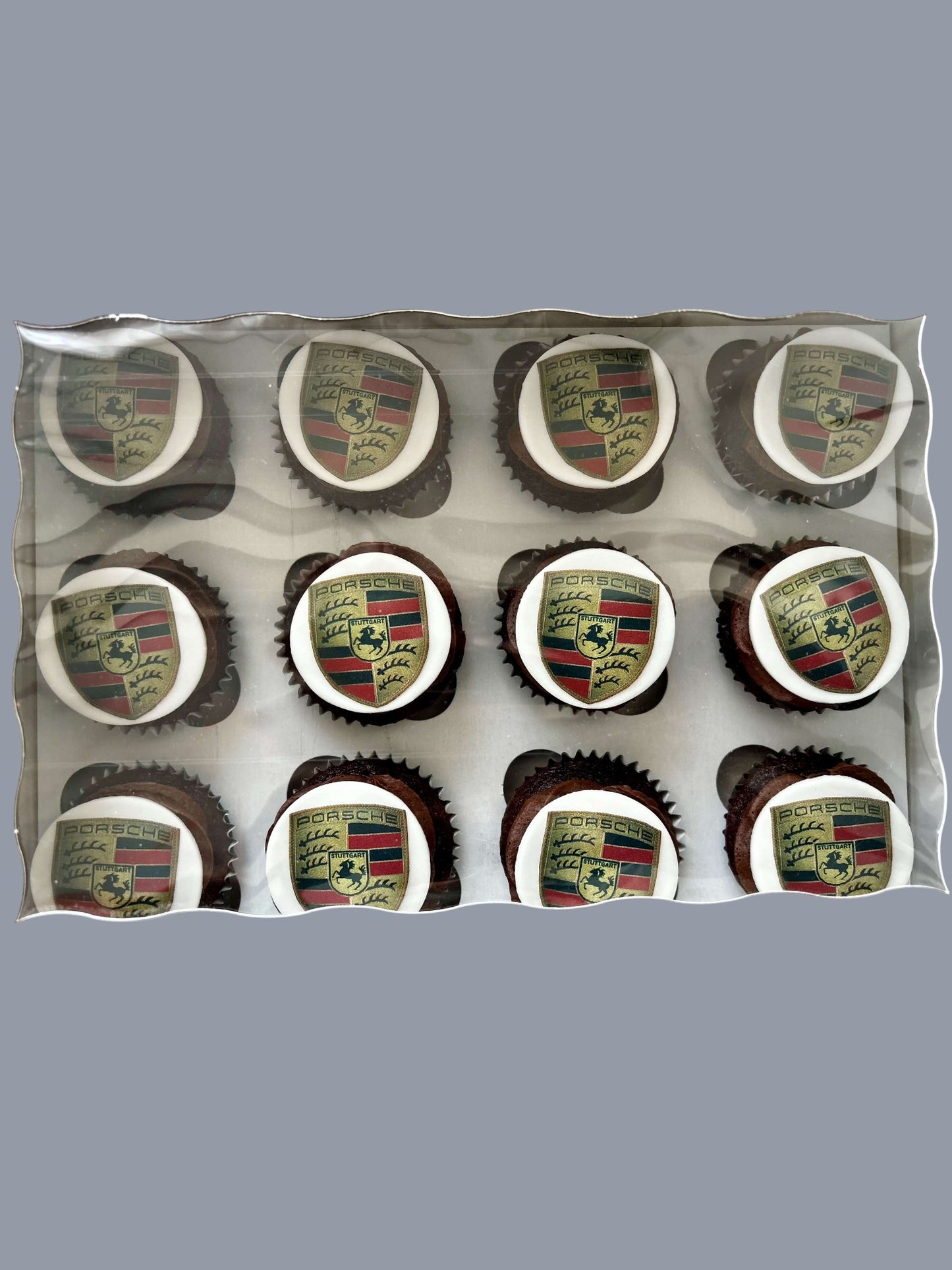 Sarah's Cakes dozen chocolate cupcakes topped with white fondant featuring the Porsche crest logo.