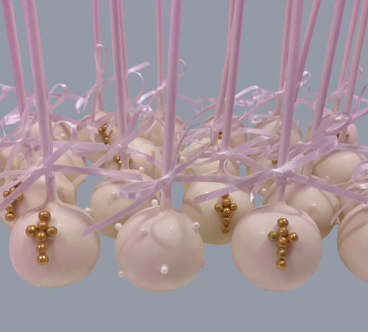 Sarah's Cakes white cake pops decorated with gold crosses and pearl sprinkles, tied with light purple ribbons.